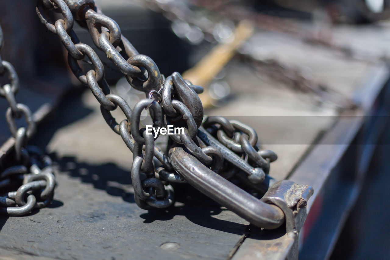 CLOSE-UP OF CHAIN HANGING ON METAL