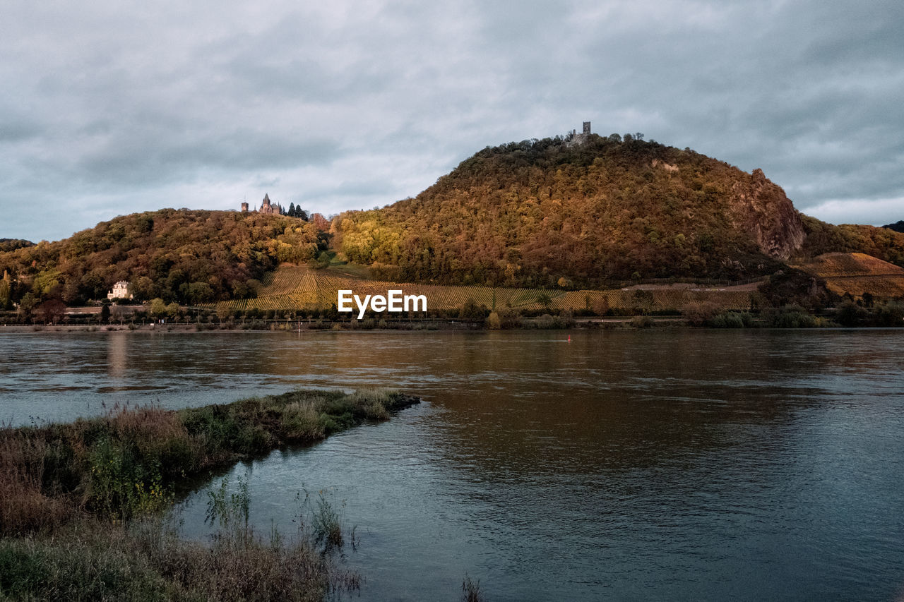 Scenic view of river and hills against sky