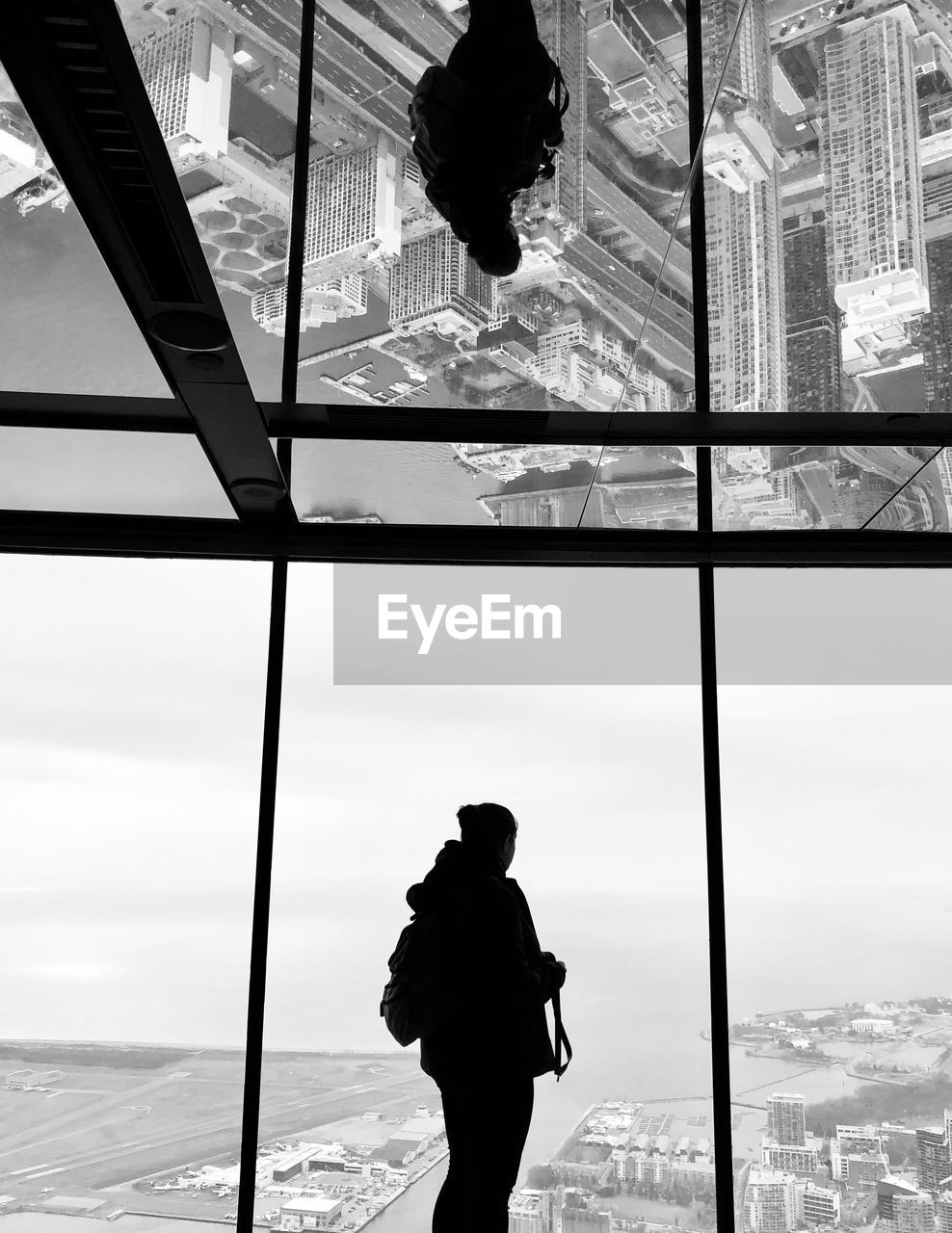 Man looking through window against sky