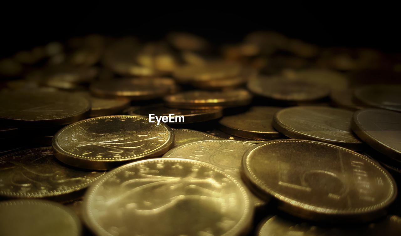 Full frame shot of golden coins in darkroom