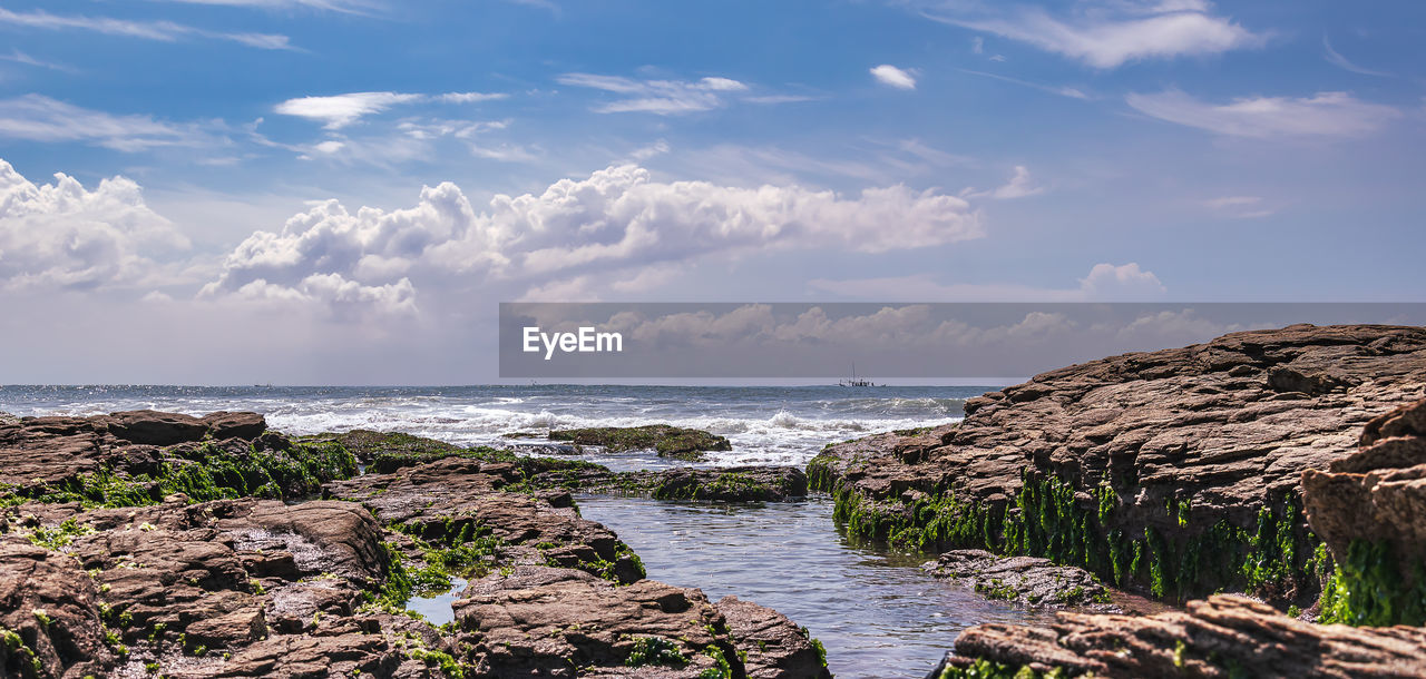 Views of the coast of west africa in ghana with cliffs and fishing boat on the horizon