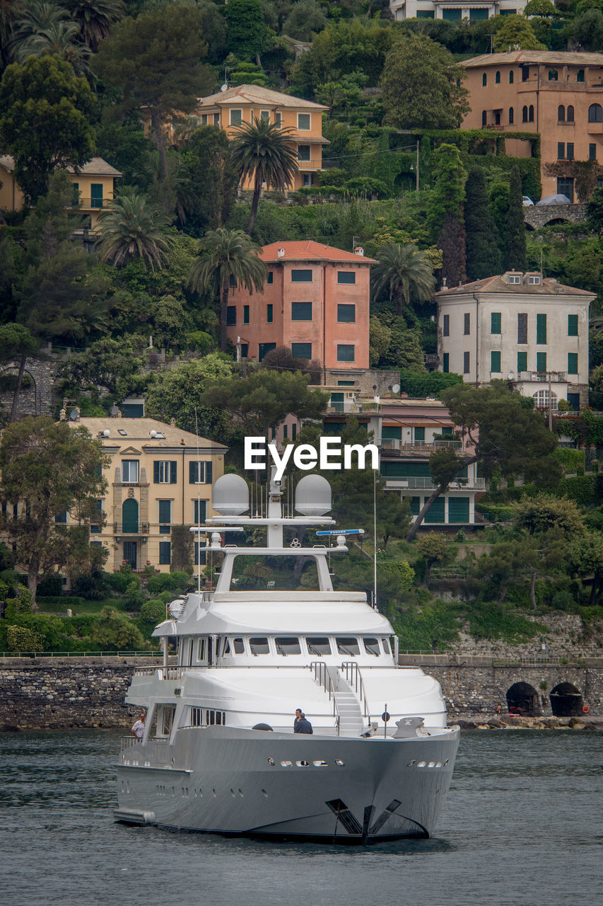 BOATS MOORED IN SEA AGAINST BUILDINGS