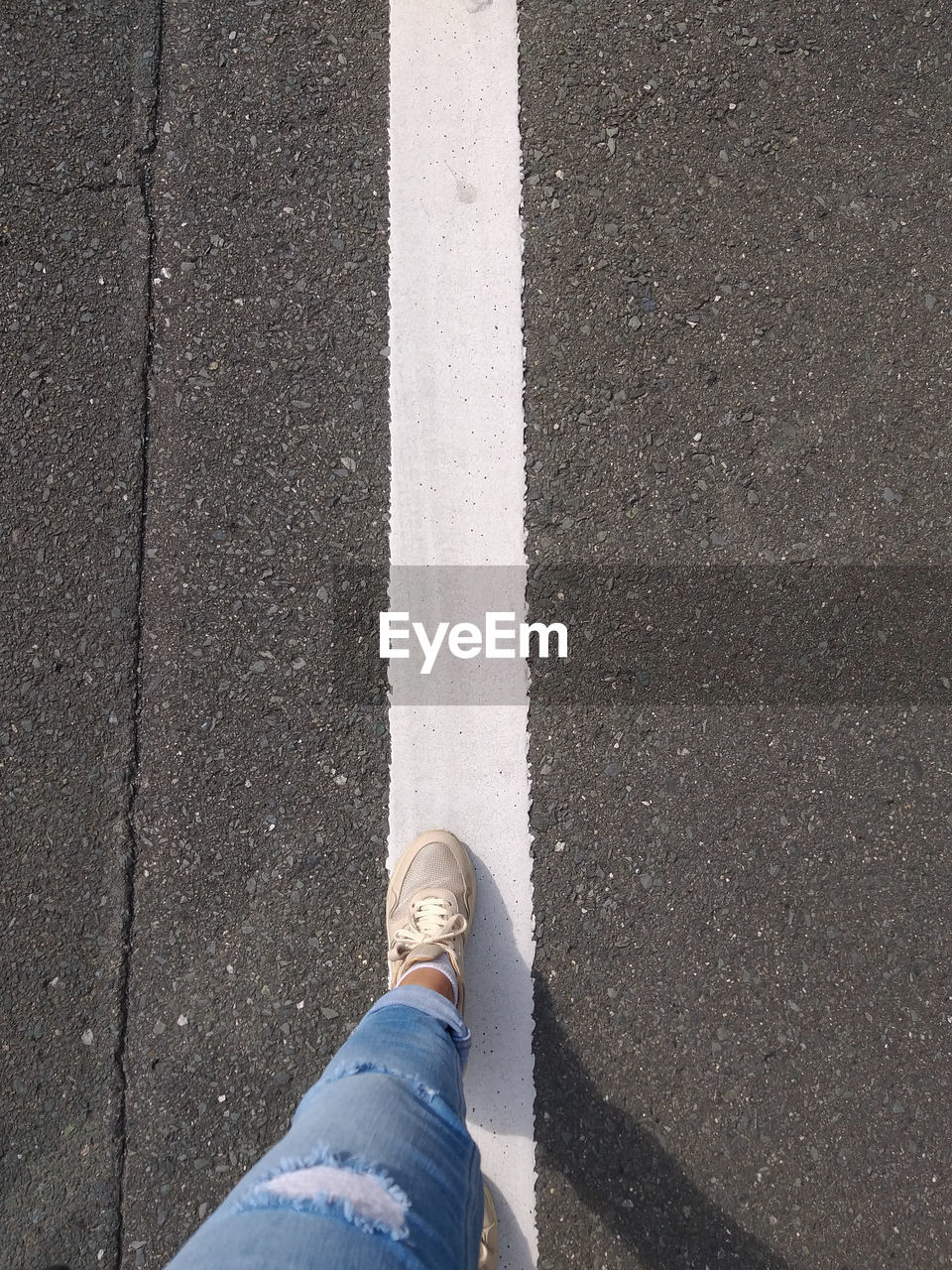 Low section of person standing on road