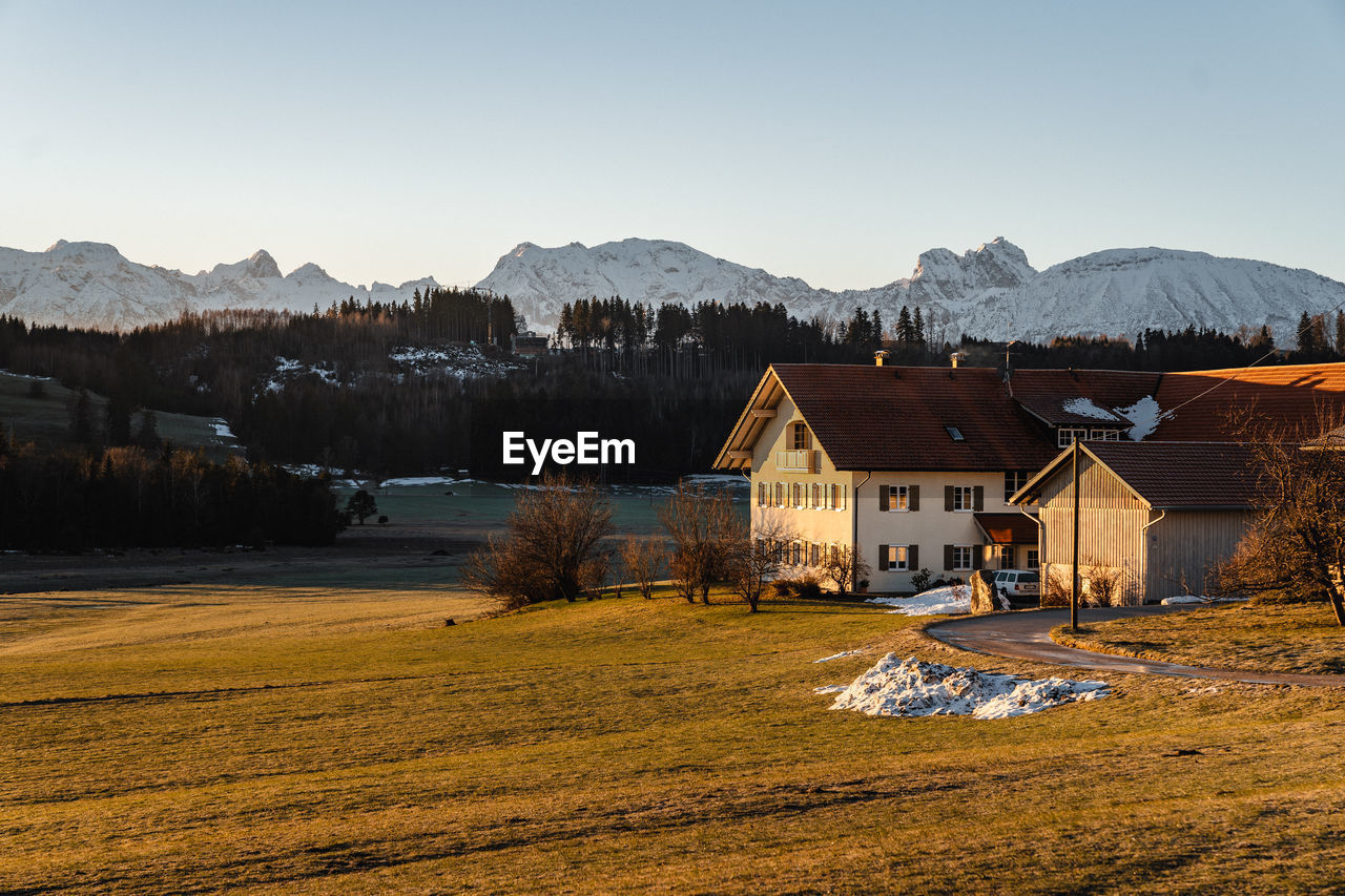 Houses on field against clear sky