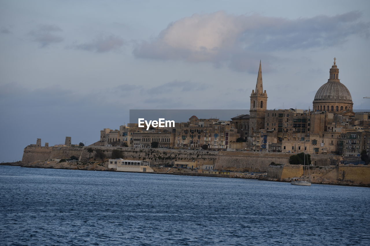 VIEW OF CATHEDRAL WITH SEA IN BACKGROUND AGAINST CLOUDY SKY