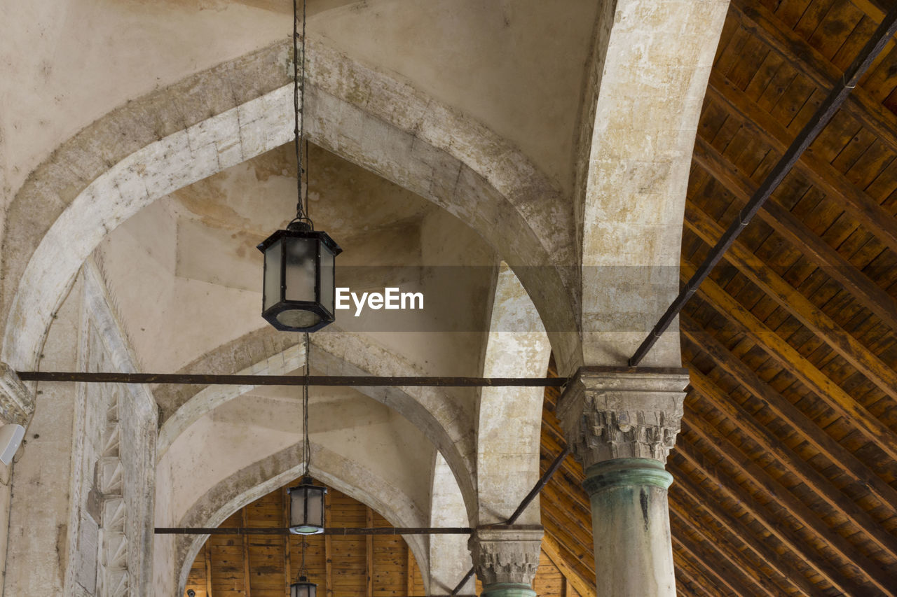 Low angle view of pendant lights hanging from ceiling of building