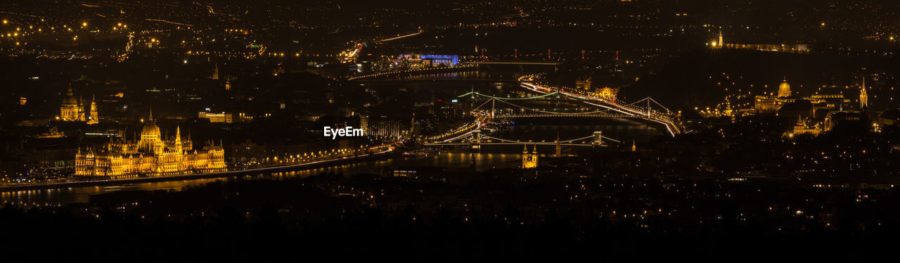 Panoramic view of illuminated parliament building and bridge at night