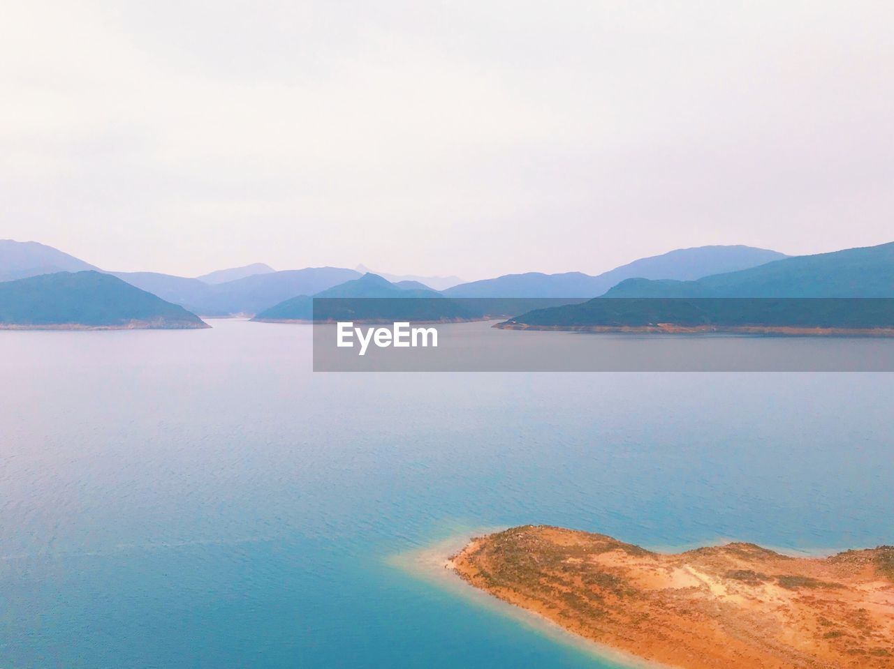 Scenic view of sea and mountains against sky