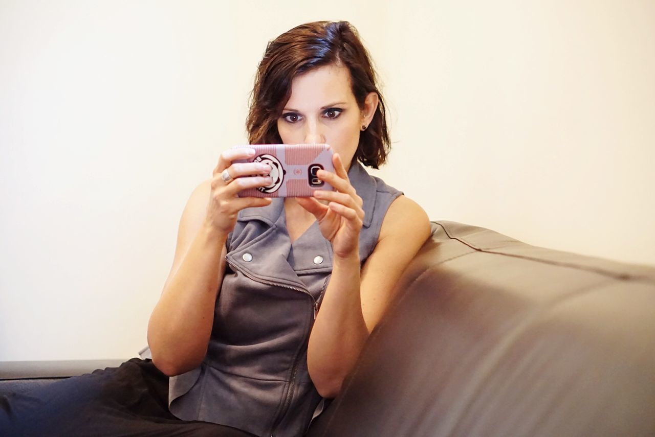 PORTRAIT OF BEAUTIFUL YOUNG WOMAN PHOTOGRAPHING AT HOME