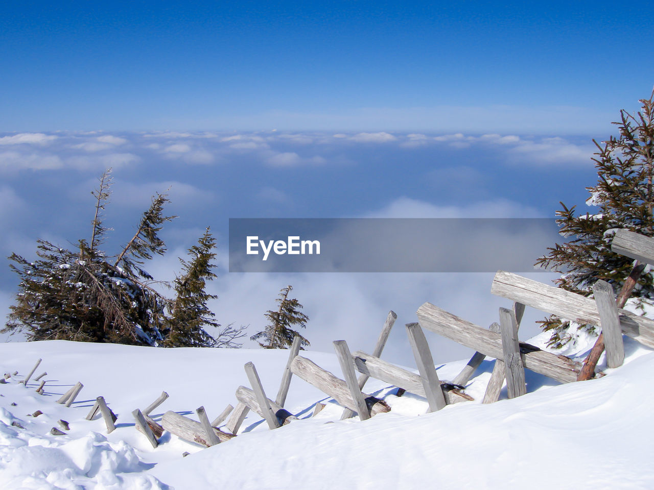 Snow covered landscape against blue sky