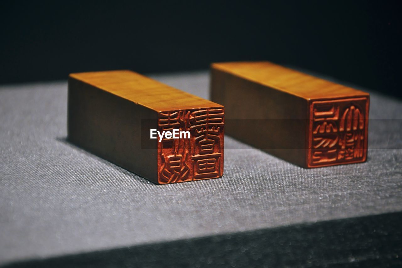 Close-up of chinese stamps on table against black background