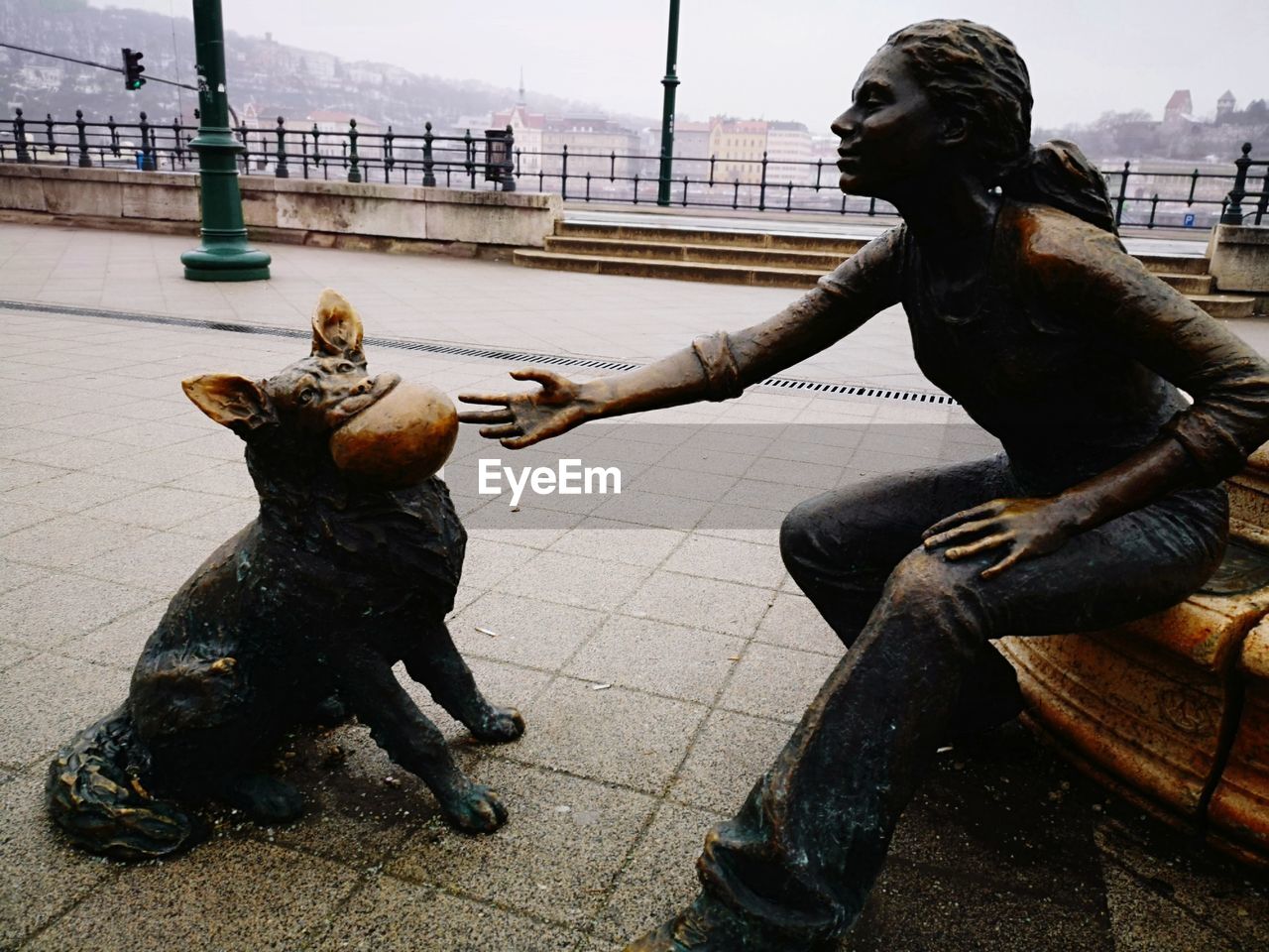 STATUE OF MAN IN CITY AGAINST SKY