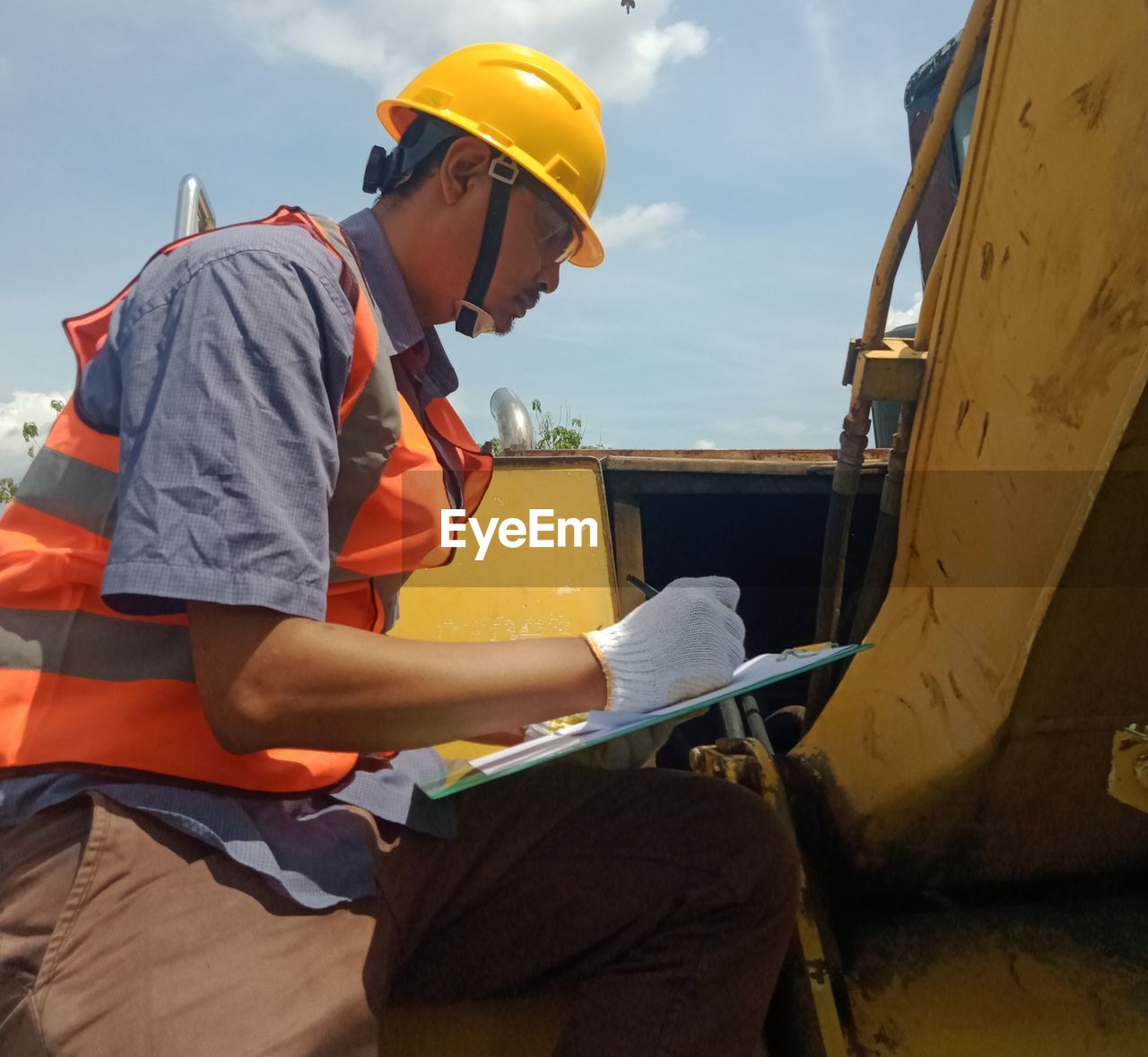 REAR VIEW OF MAN WORKING AT BUS