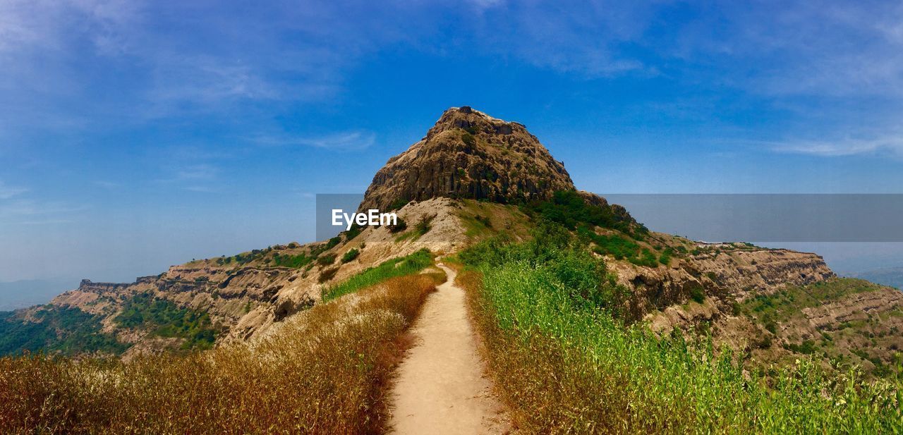 Scenic view of mountain against blue sky