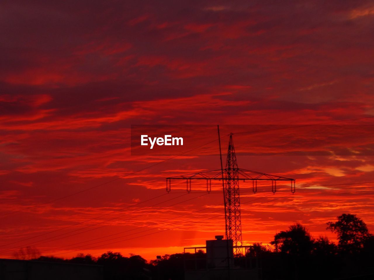 LOW ANGLE VIEW OF SILHOUETTE ELECTRICITY PYLON AGAINST ORANGE SKY