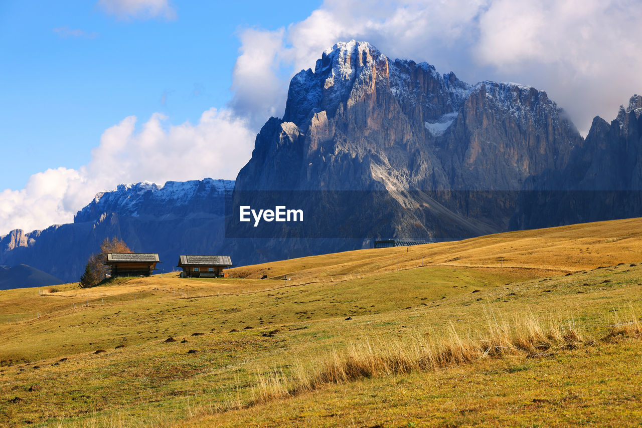 scenic view of field by mountains against sky