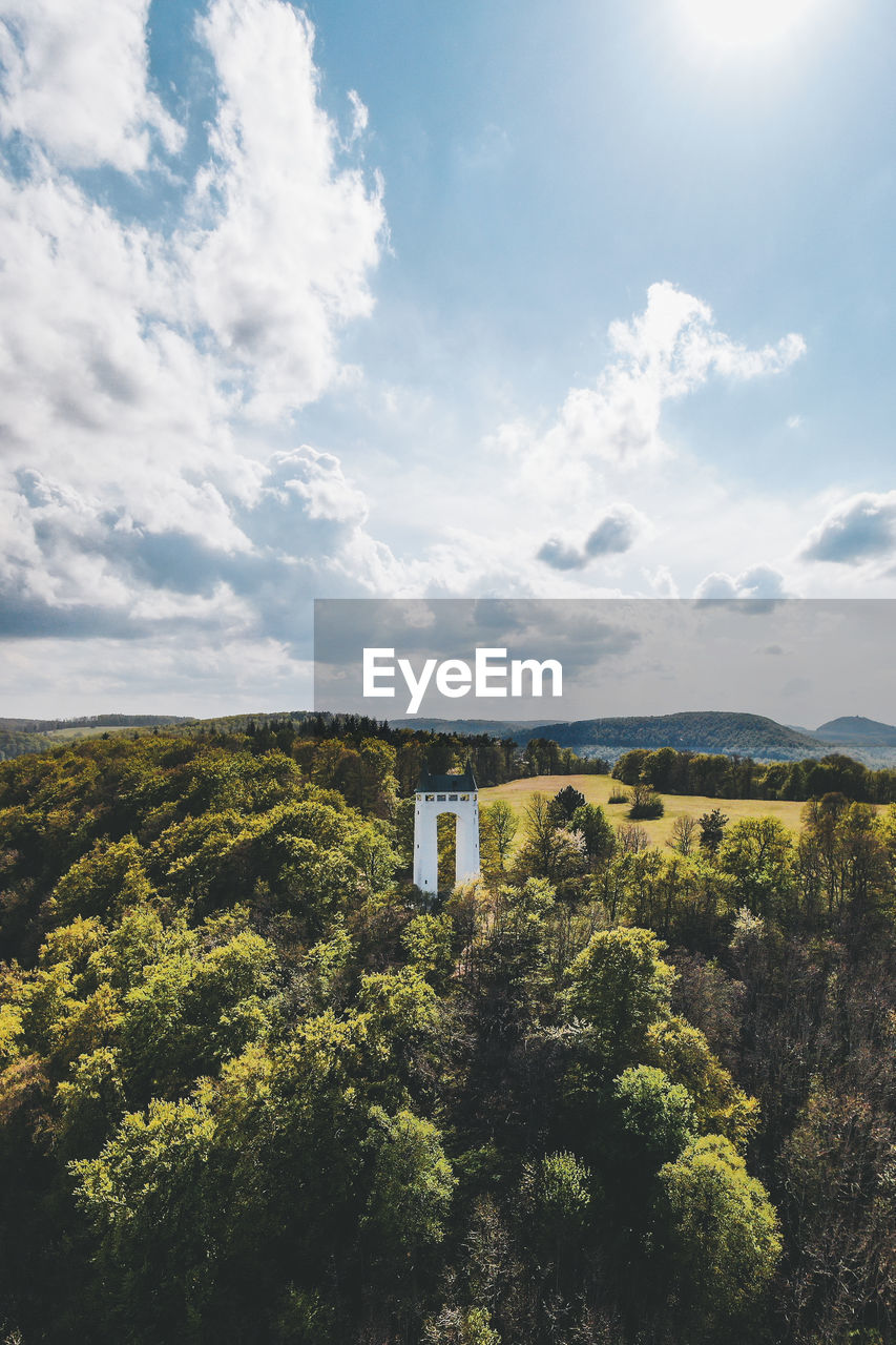 Aerial view of built structure amidst trees against sky