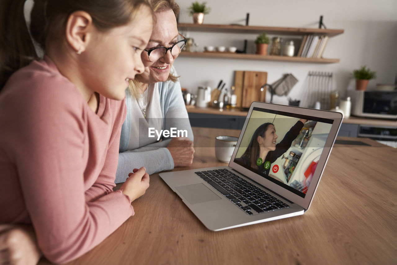 Grandmother and granddaughter talking on video call at home