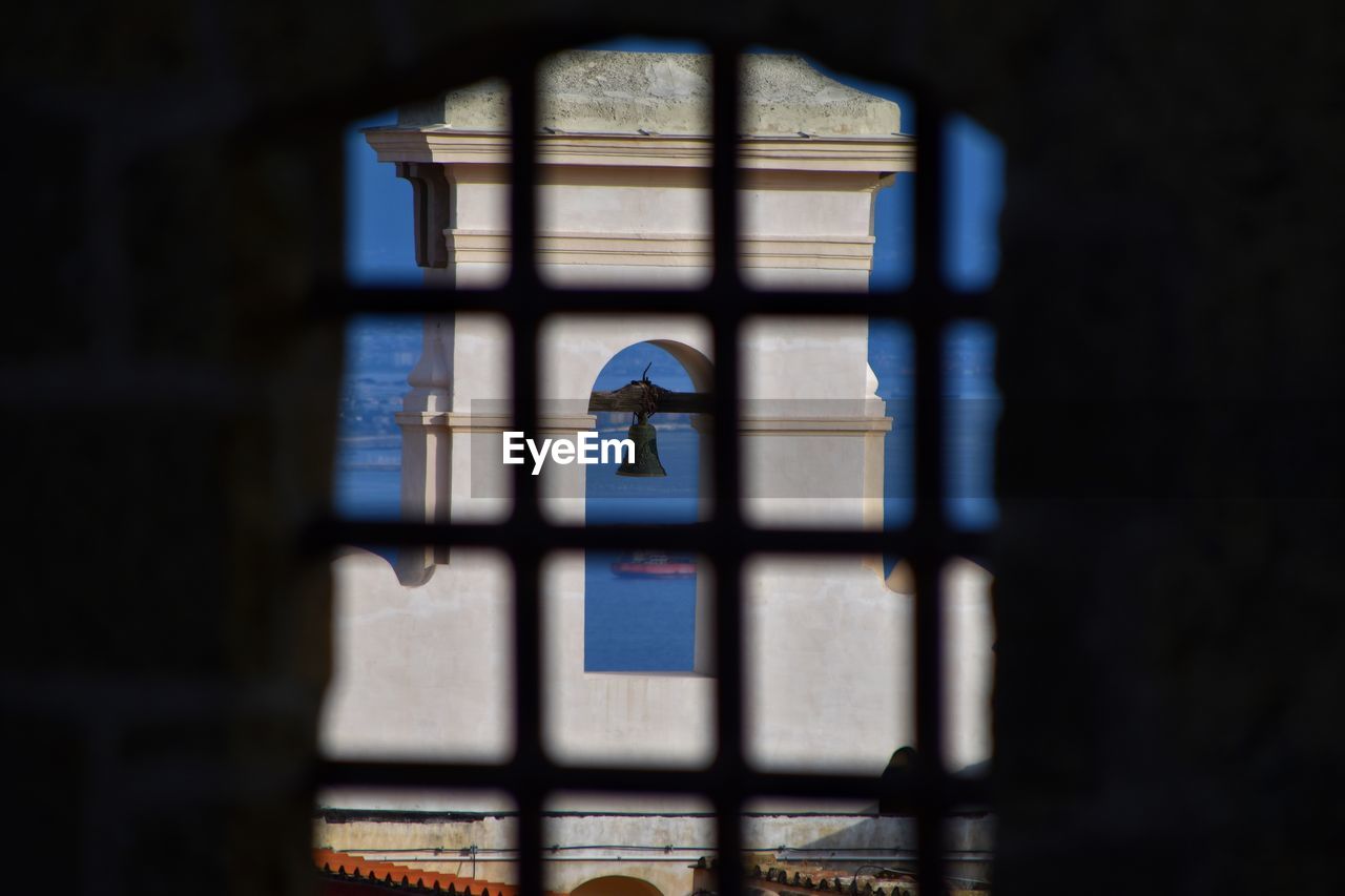 window, blue, light, architecture, building, built structure, no people, darkness, glass, lighting, indoors, religion, place of worship, belief, prison, day, spirituality, stained glass, nature, punishment, iron, shadow, security