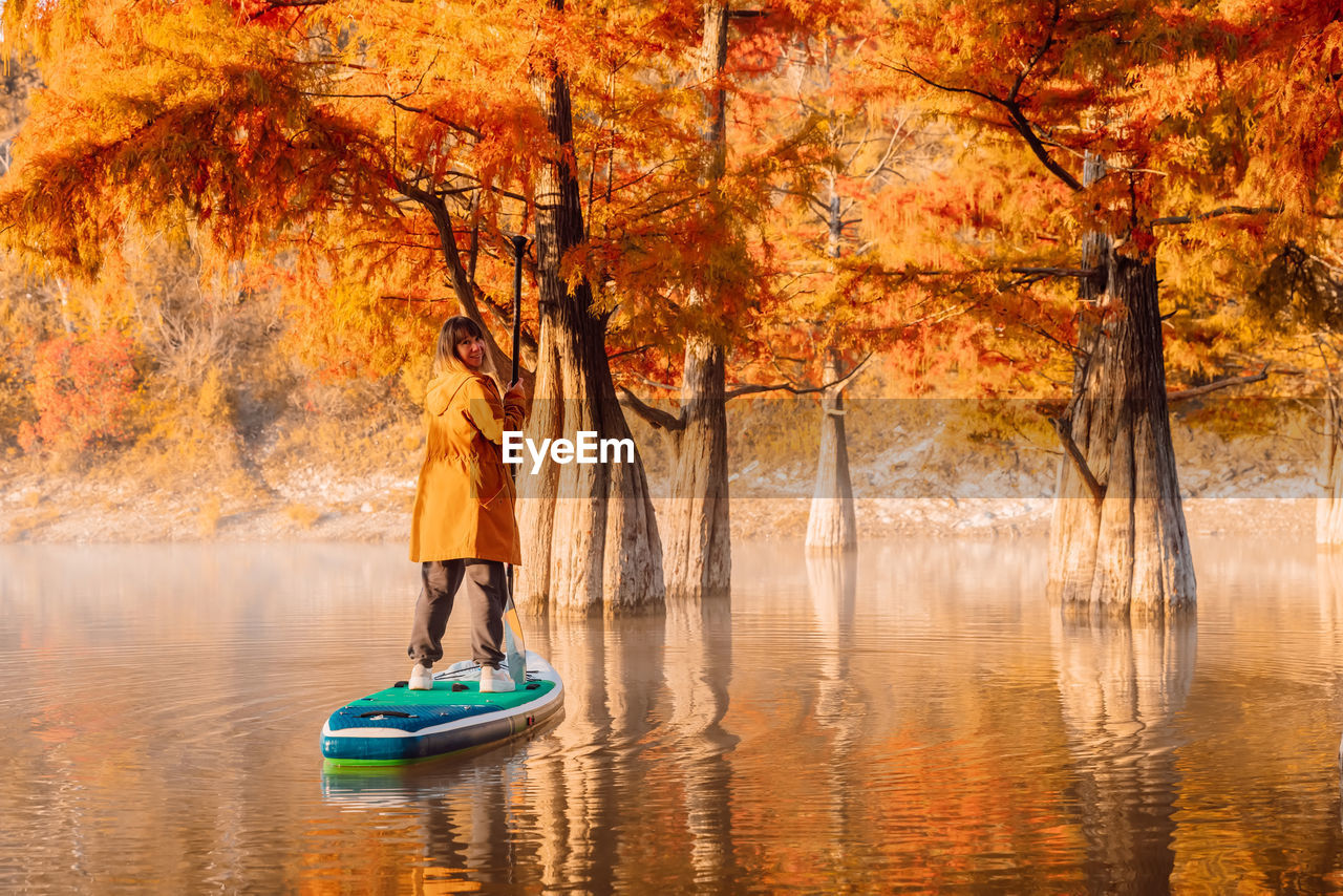 rear view of woman in boat on lake during autumn