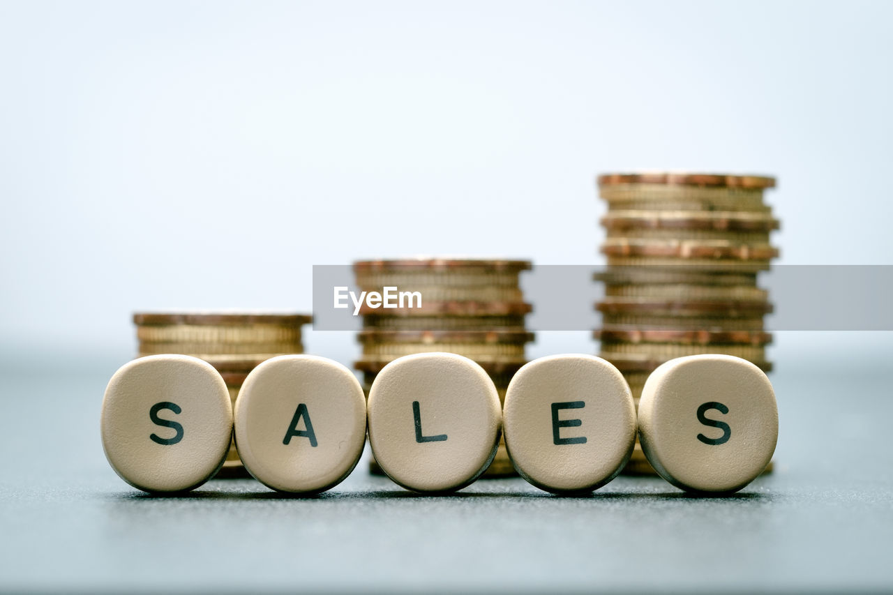 Close-up of text and coins on table against white background
