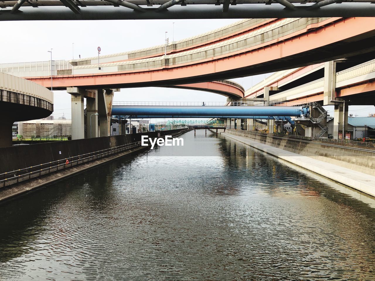 BRIDGE OVER RIVER WITH CITY IN BACKGROUND