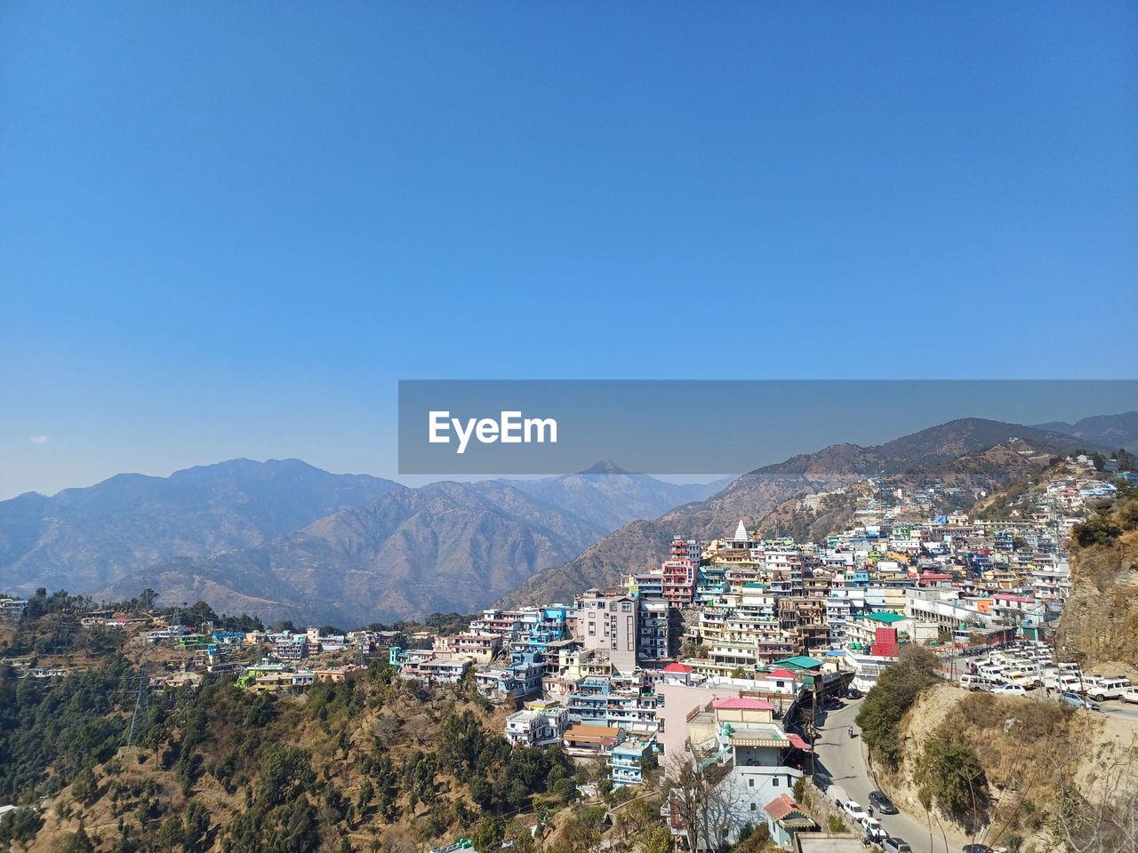 mountain, architecture, town, sky, city, mountain range, building exterior, nature, building, built structure, landscape, environment, scenics - nature, blue, land, clear sky, high angle view, residential district, travel destinations, travel, house, outdoors, aerial photography, day, no people, sunny, vacation, cityscape, beauty in nature, village, tree, copy space, tourism, plant, sea, sunlight