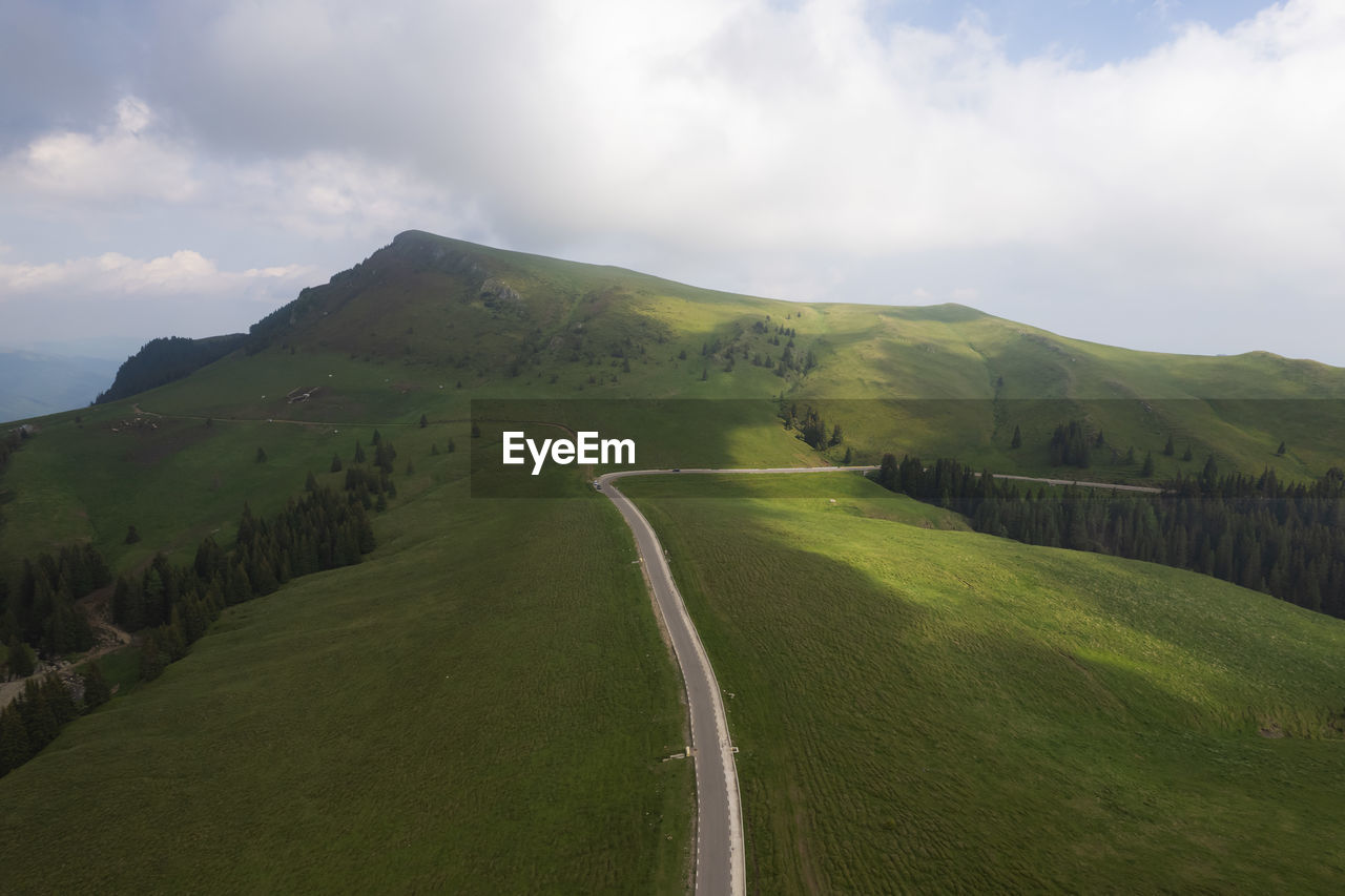 environment, landscape, sky, cloud, hill, land, scenics - nature, highland, nature, plant, beauty in nature, mountain range, road, mountain pass, grassland, green, grass, travel, no people, ridge, rural area, non-urban scene, tranquility, travel destinations, tree, transportation, plain, plateau, rural scene, tourism, outdoors, tranquil scene, forest, social issues, field, fog, day, water, lake, environmental conservation, meadow, activity, overcast, idyllic, valley, vacation, trip, holiday, summer
