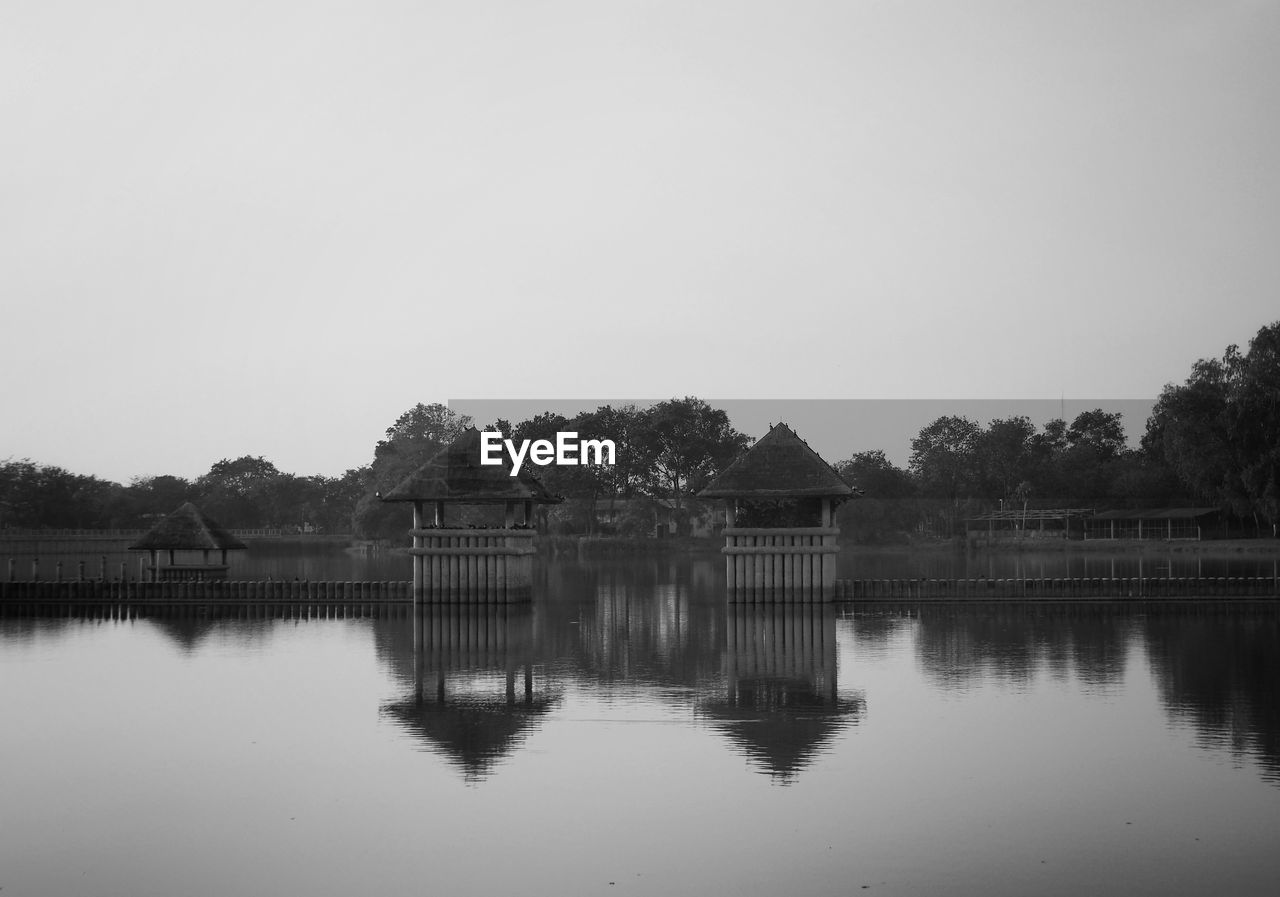 Built structure by lake against clear sky