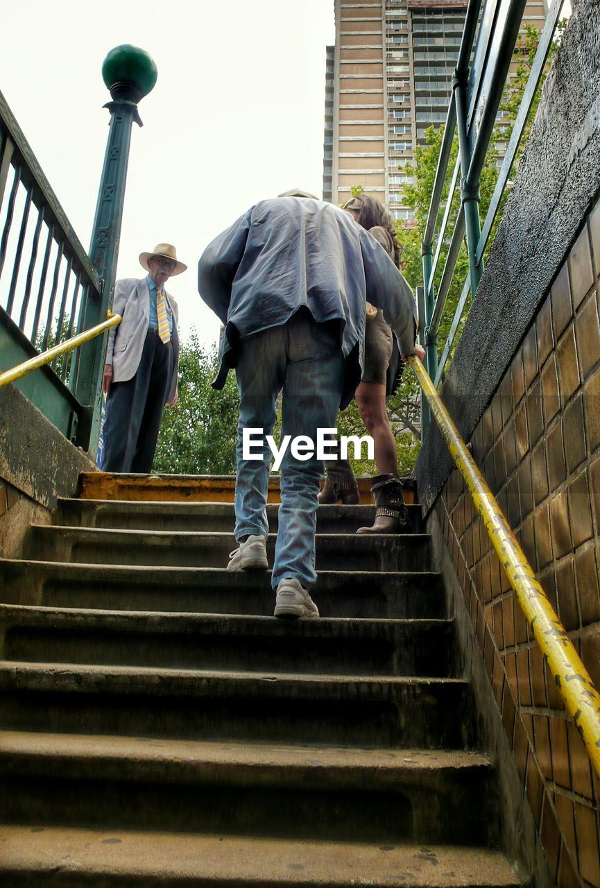 LOW ANGLE VIEW OF WOMAN WALKING UP STAIRS