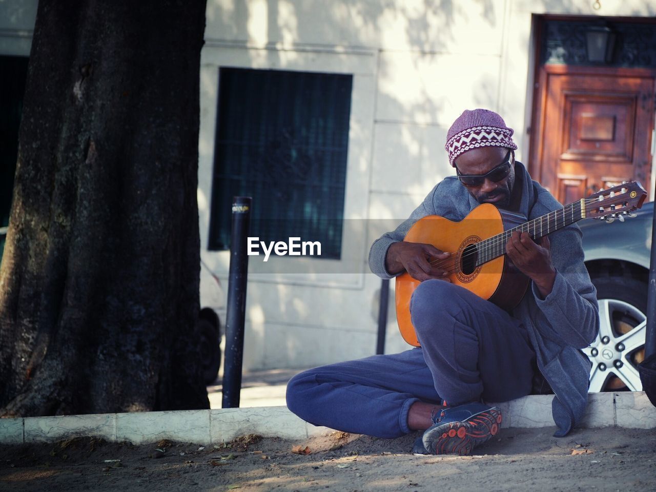 YOUNG MAN PLAYING GUITAR AT THE CAMERA