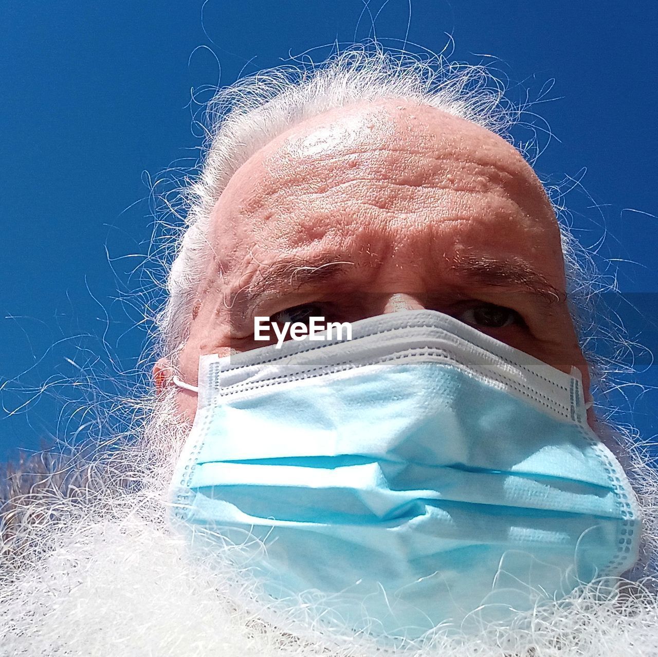 CLOSE-UP PORTRAIT OF A WOMAN AGAINST BLUE SKY