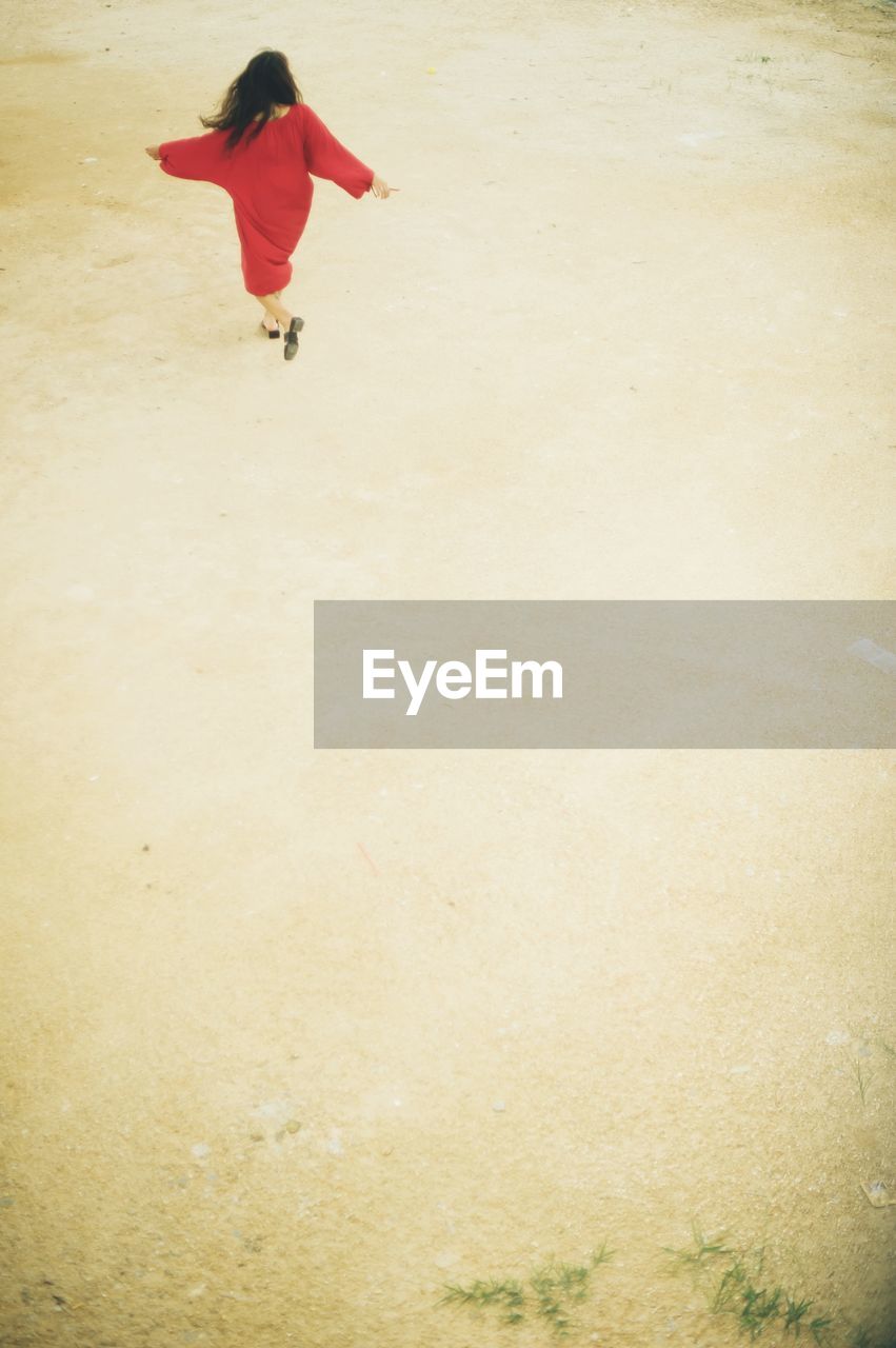 Rear view of woman running at beach