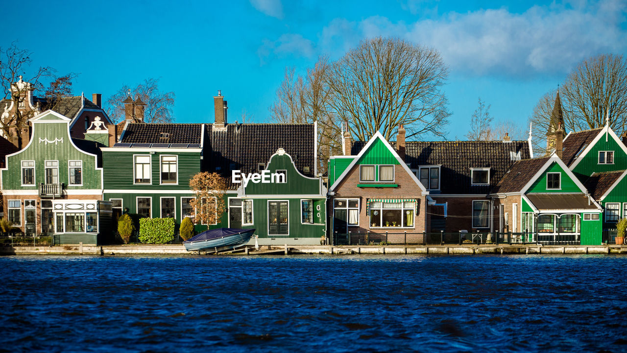 HOUSES BY SWIMMING POOL BY BUILDINGS AGAINST SKY