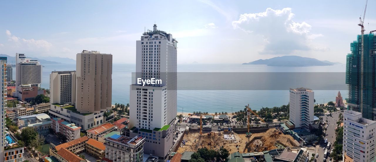 Panoramic view of sea and buildings against sky