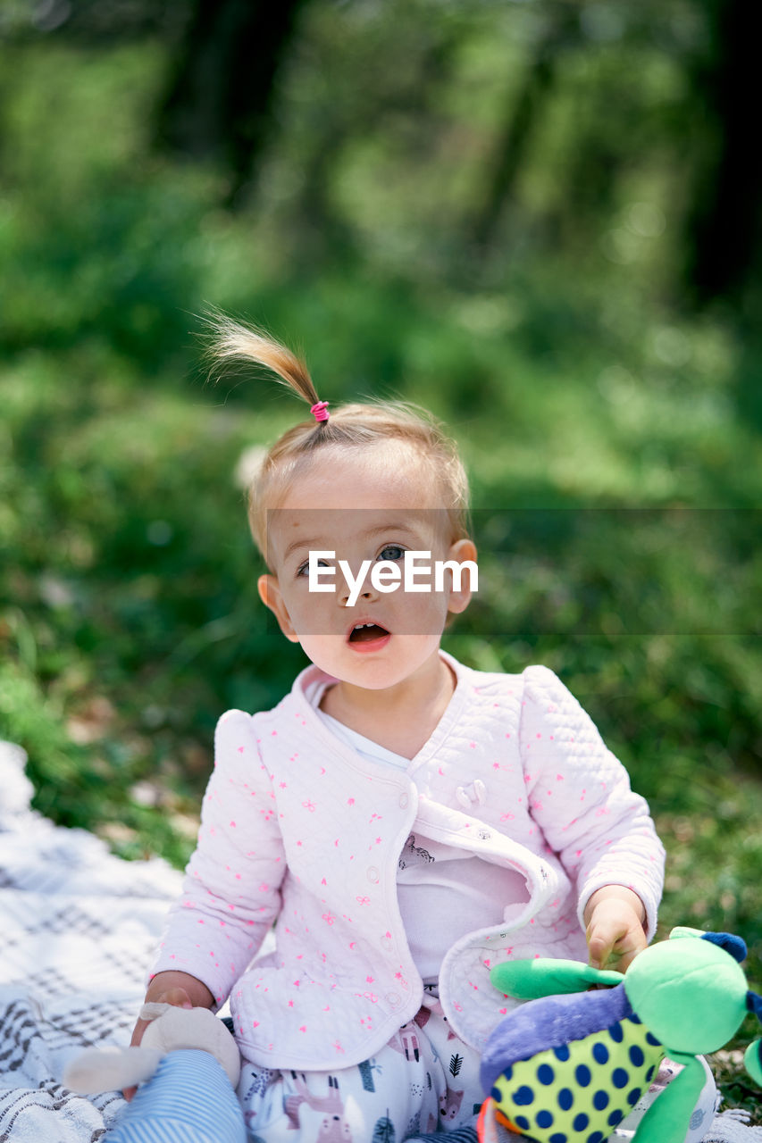 PORTRAIT OF CUTE BABY BOY SITTING OUTDOORS