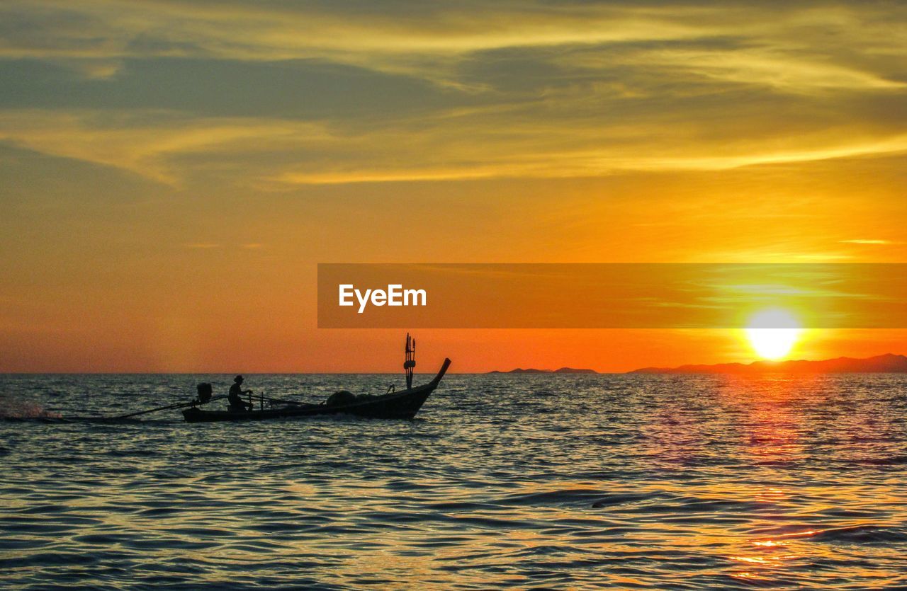 Silhouette of boat on sea at sunset