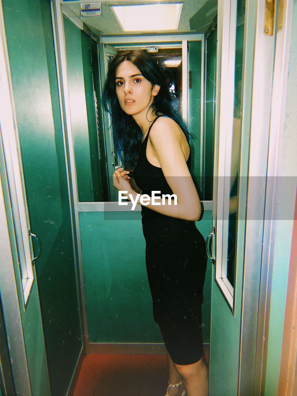 Side view portrait of young woman standing in elevator