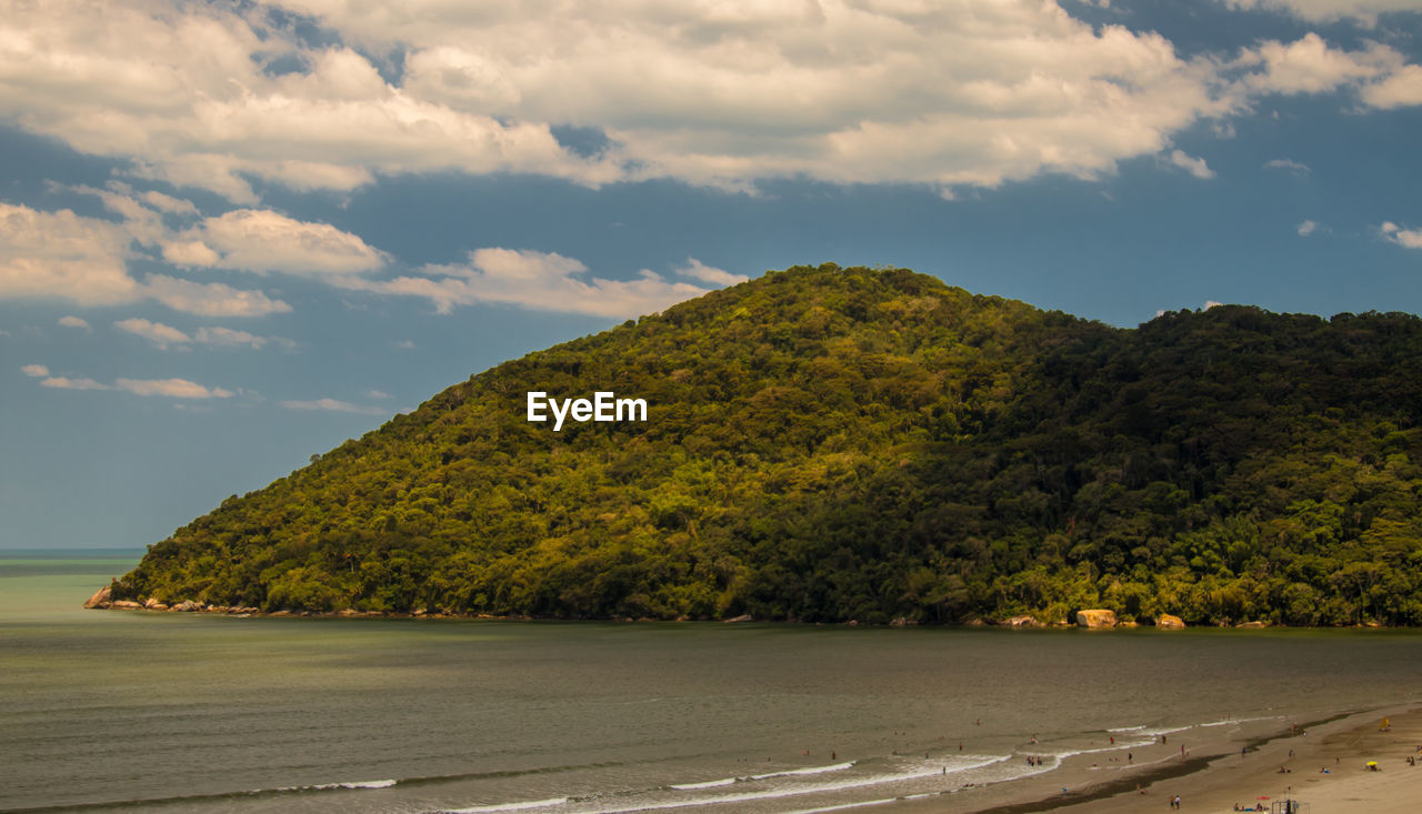 Scenic view of mountain by sea against sky