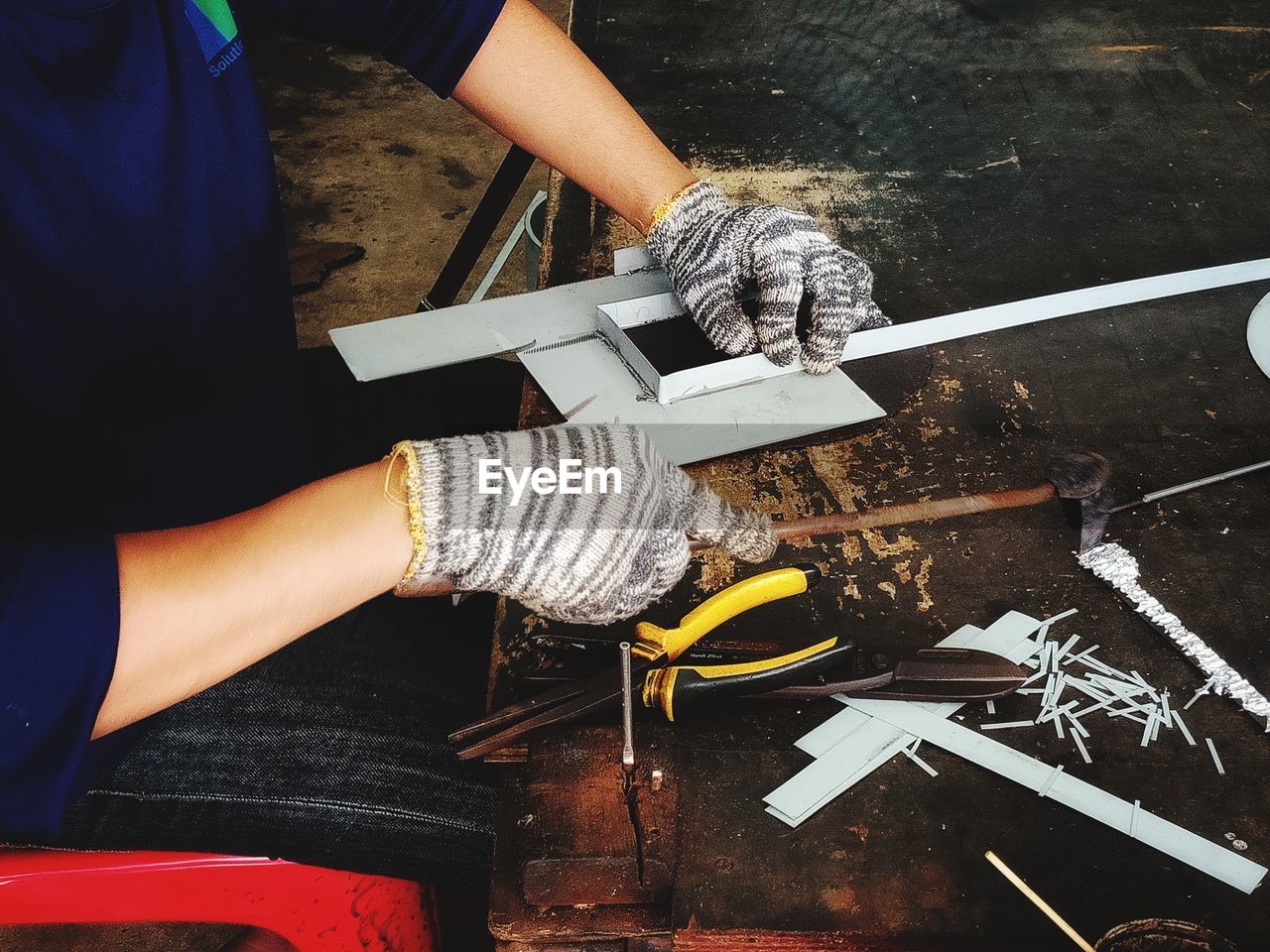 Midsection of man working on desk in workshop