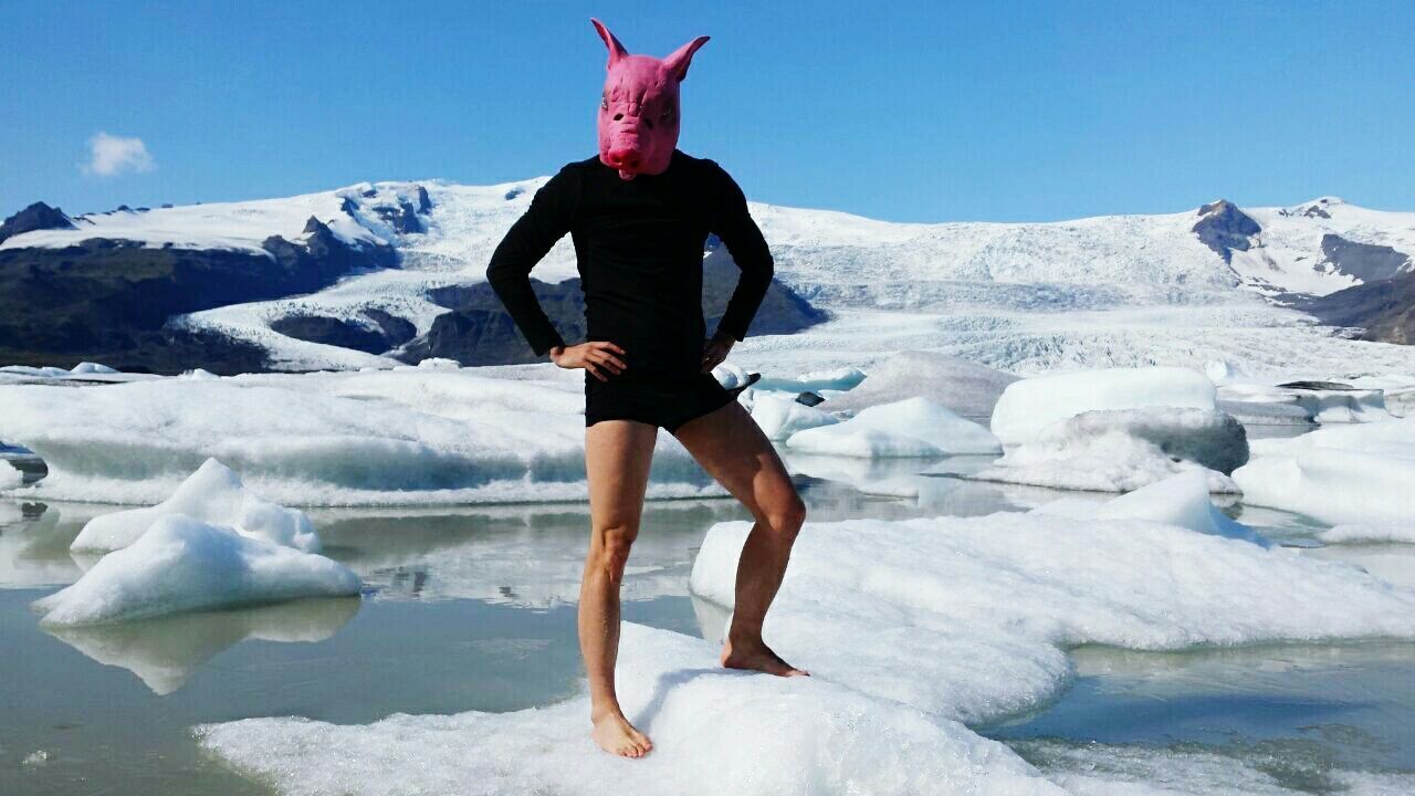 Man wearing pig mask while standing on frozen lake