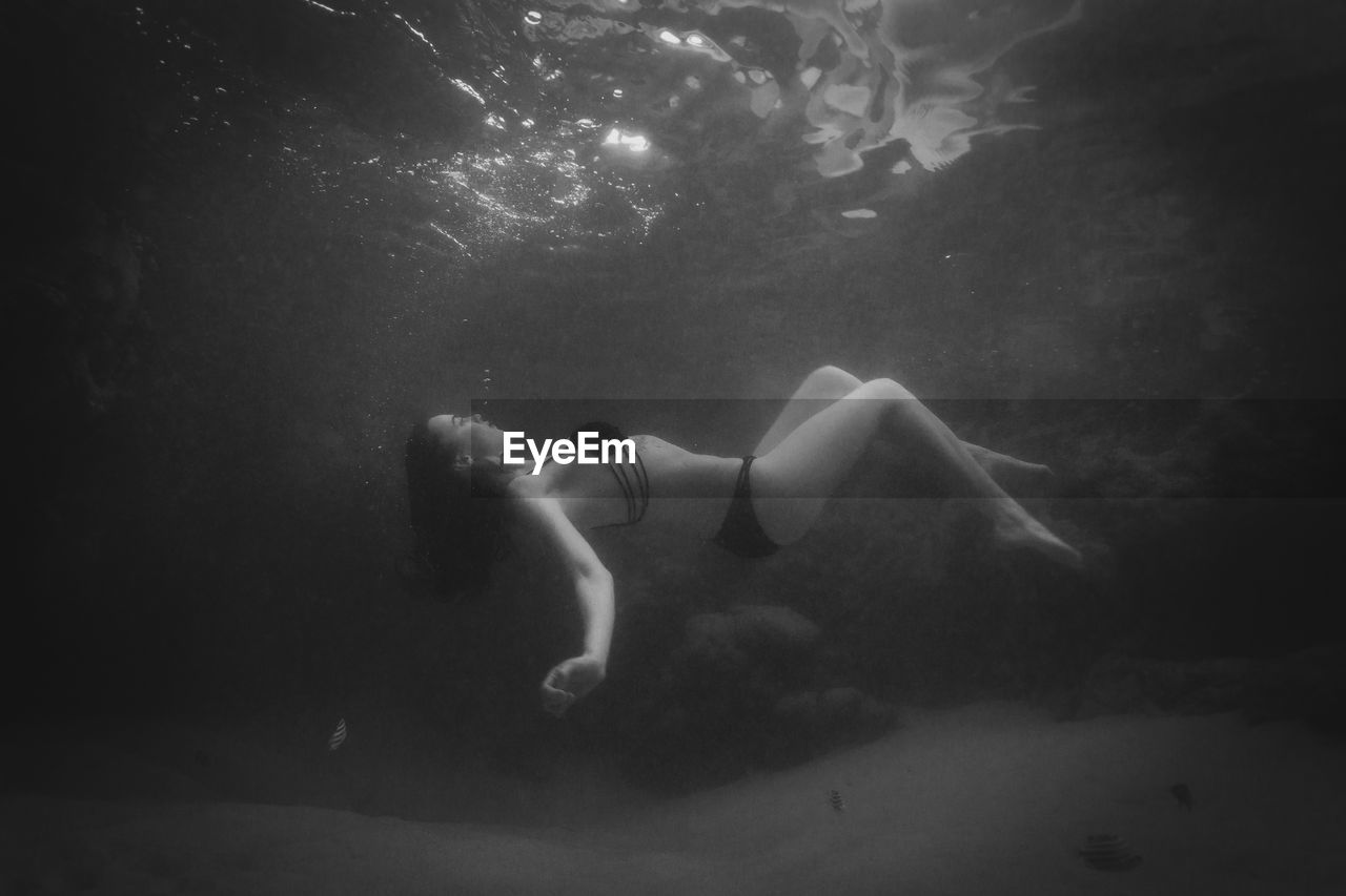 Young woman swimming underwater in sea