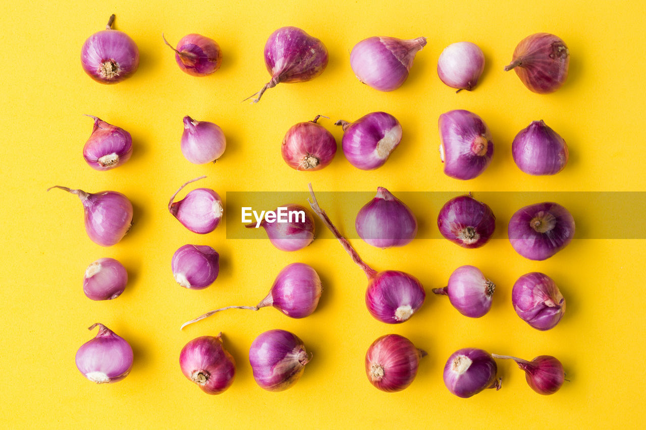 Fresh shallots-red onions on the yellow background-top view