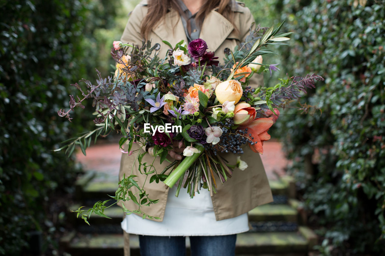 CLOSE-UP OF WOMAN HOLDING FLOWER