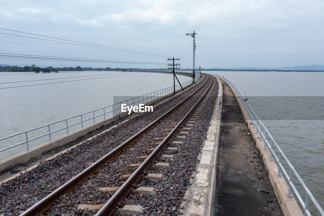 Railway bridge above the reservoir of pa sak jolasid dam at lopburi, amazing thailand in the rain 