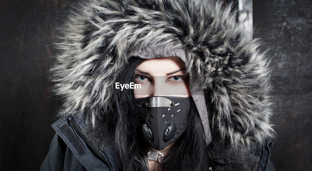 Close-up portrait of young woman wearing parka during winter