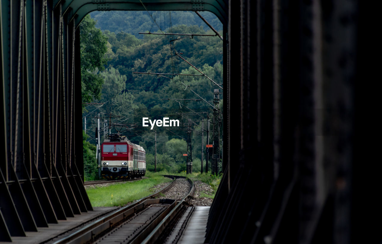 TRAIN ON RAILROAD TRACKS SEEN THROUGH WINDOW