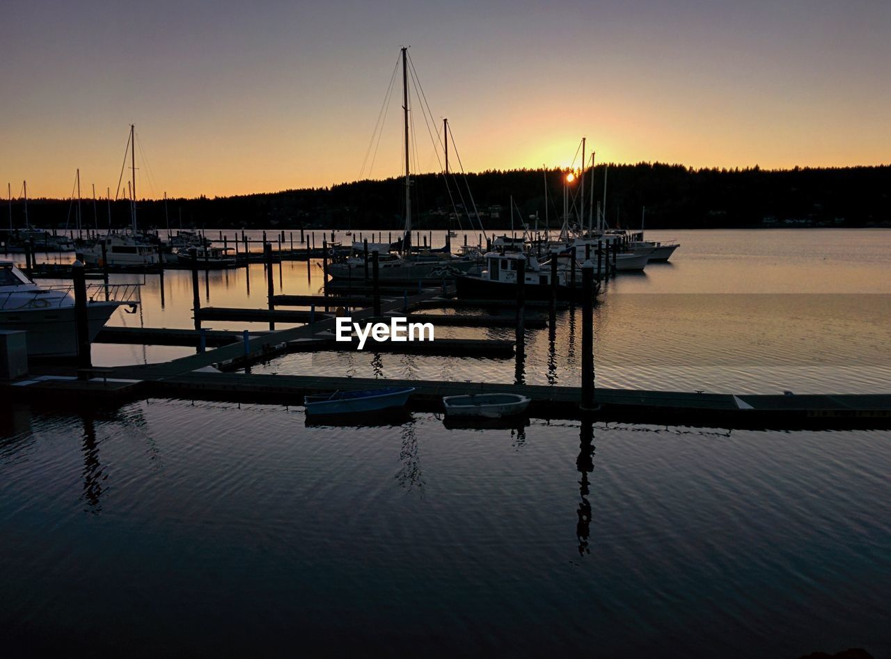 SILHOUETTE BOATS AGAINST SKY DURING SUNSET