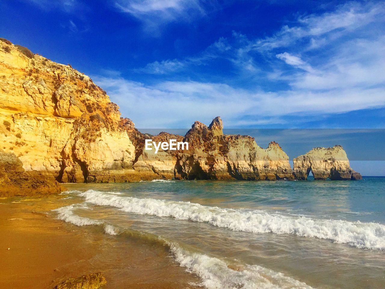 Rock formations by sea against sky