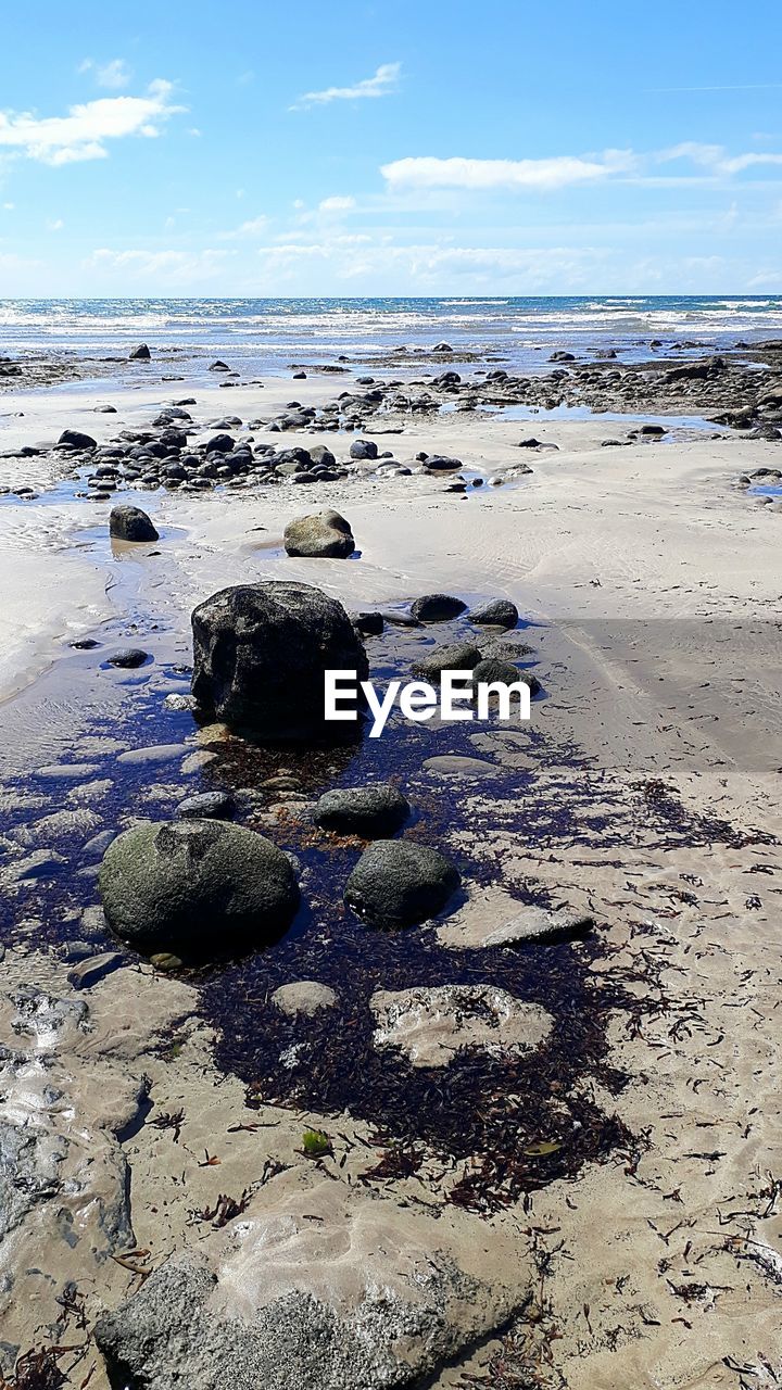 SCENIC VIEW OF ROCKS ON SHORE AGAINST SKY